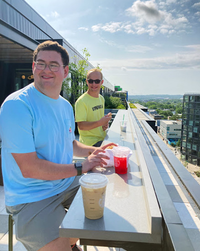 bb-living-sleepover-5 Two male Best Buddie's Sleepover participants enjoy eating lunch on the balcony of their apartment.